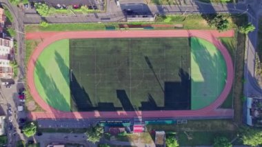 Önünde küçük bir futbol stadyumu olan havacılık şehri manzarası.
