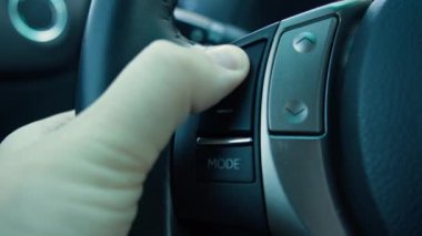 Direksiyondaki düğmelere basan adam. Direksiyondaki modern düğmeler