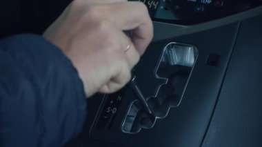 Arabada vites değiştiren bir adam. Sürücü otomatiği kontrol eder ve vites değiştirir.