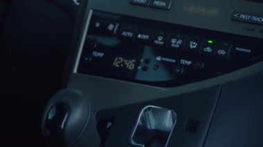 Otomatik vites değiştiren bir adam. Adamın eli vites değiştirme iletimini kontrol ediyor