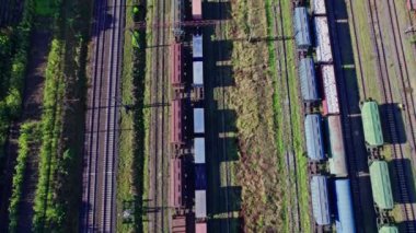 Aerial view from flying drone of colorful freight trains on the railway station