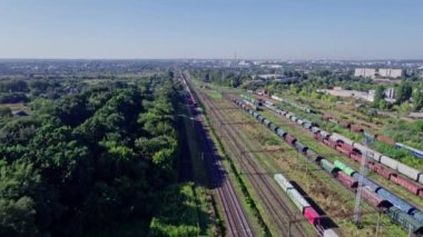 Aerial view from flying drone of colorful freight trains on the railway station