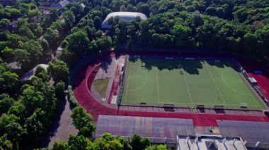 Küçük bir kasabada sokakları olan binaların arkasında futbol sahası boş.