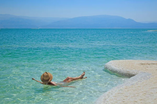 Girl relaxing in the water of Dead Sea