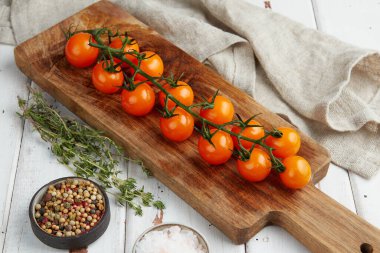 Beyaz ahşap zemin üzerinde taze sarı kiraz domatesleri.