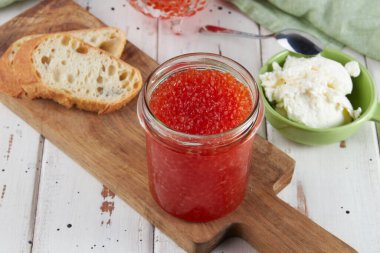 Tahta bir masada kırmızı havyar, havyarlı bruschetta.