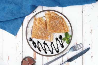 Tabağa doldurulmuş krepler, ince krepler, blini, beyaz ahşap masa.