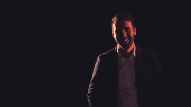 4k βίντεο βραδείας κίνησης του χαμογελαστού άνδρα σε μαύρο φόντο. — Αρχείο Βίντεο