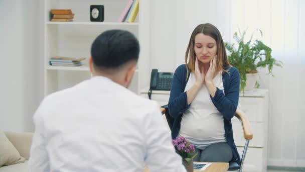 4kビデオの悲しい妊娠中の女性と話す医師. — ストック動画
