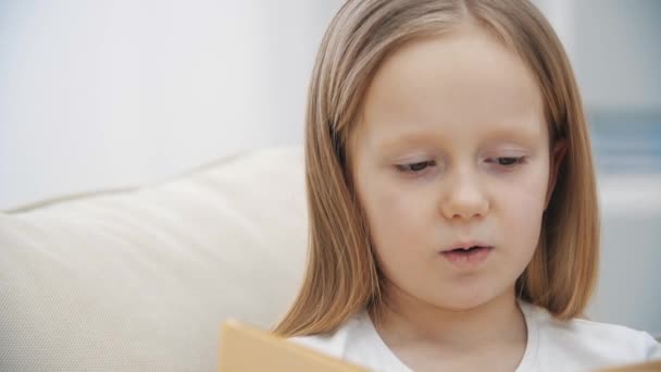 4k відео маленької дівчинки, що читає книгу . — стокове відео