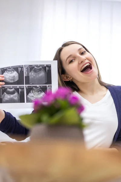 Foto einer lächelnden Schwangeren mit Ultraschallbild. — Stockfoto
