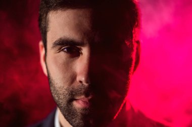 Pembe arka planda kameraya bakan adamın yakın fotoğrafını çek. Ciddi adam kavramı.