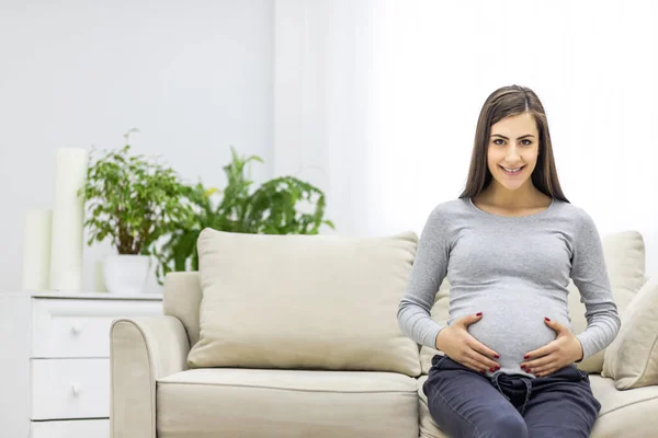 妊娠中の女性のカメラを見て 彼女の胃に触れる写真 妊婦の概念 — ストック写真