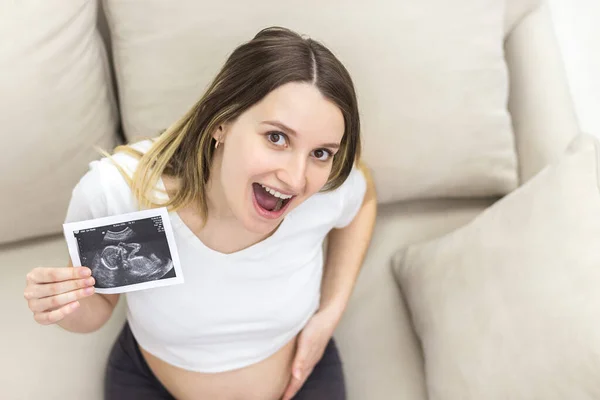 Foto von schwangerer Frau mit offenem Mund mit Ultraschallbericht. — Stockfoto