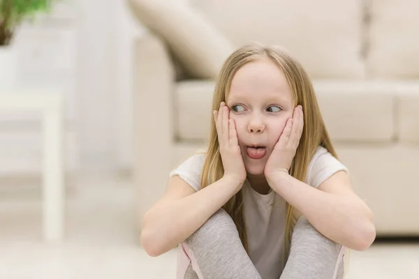 Foto de menina loira pequena mostrando língua. — Fotografia de Stock