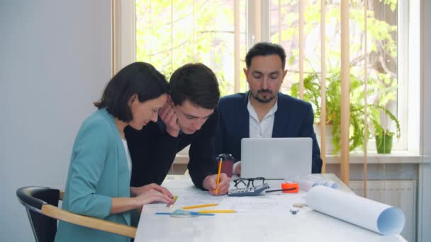 4k video de colegas en ropa formal discutiendo ideas de negocios mientras se reúnen en la mesa en la oficina moderna. — Vídeos de Stock