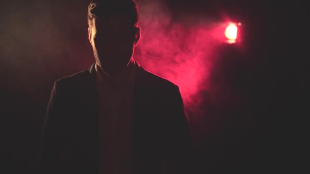 4k-Video des rauchenden Mannes in Anzug und rotem Licht auf dem Hintergrund. — Stockvideo