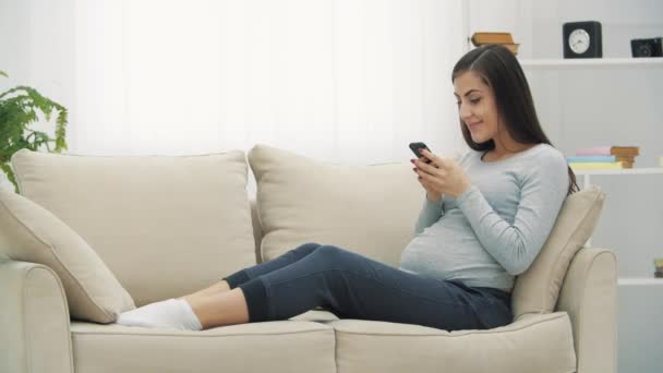4k video av gravida kvinna med hjälp av telefon. — Stockvideo