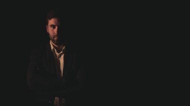 Siyah arka planda siyah takım giyen bir adamın 4K yavaş çekim videosu..