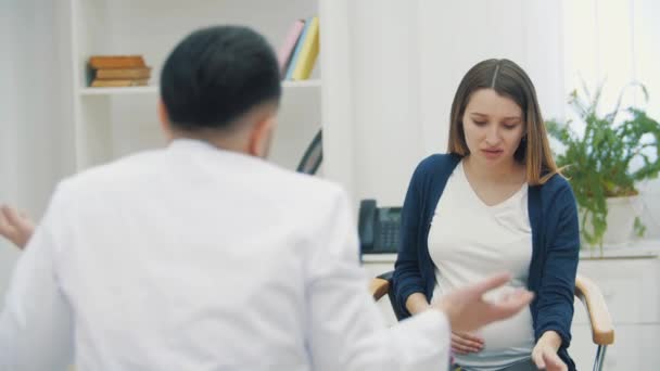 4k video av ledsen gravid kvinna talar med en läkare. — Stockvideo
