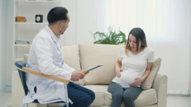 Hamile kadın ve doktorun 4K videosu tıbbi sonuç ve ultrason aşısı..