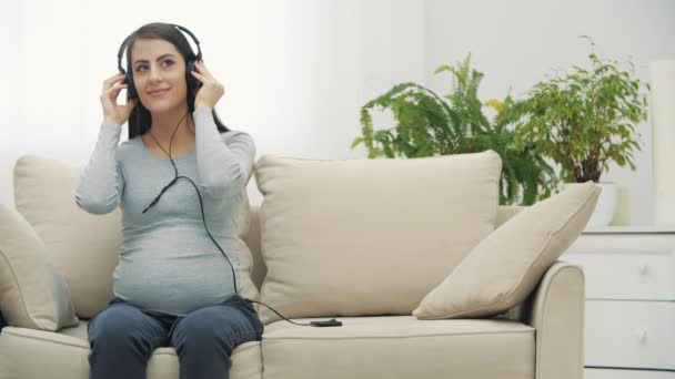 4k slowmotion video of беременная женщина слушает музыку. — стоковое видео