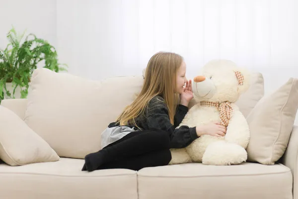 Foto de niña jugando con oso de peluche blanco. — Foto de Stock