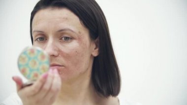 4k yavaş çekim videosu. Cildi kurumuş kadın yüzü aynaya bakıyor..