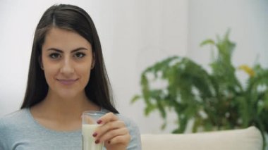 4K yavaş çekim videosu. Kadın süt içip gülümsüyor..