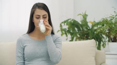 4K yavaş çekim videosu. Kadın süt içip gülümsüyor..