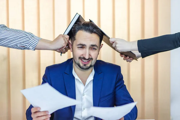 Photo d'un homme d'affaires en costume bleu ayant beaucoup de travail assis dans le bureau. — Photo