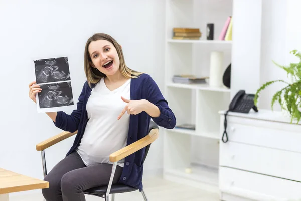 超音波検査結果を持つ妊婦の笑顔の写真. — ストック写真