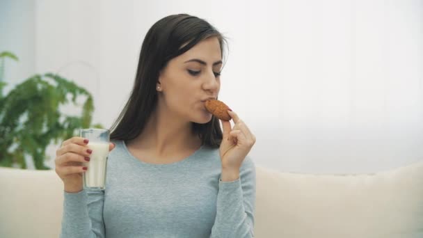 Vidéo 4k de femme enceinte avec verre de lait et biscuits. — Video