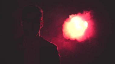 4k, gölgeli, dumanlı ve arka planda pembe ışıklı bir adamın videosunu kapat..