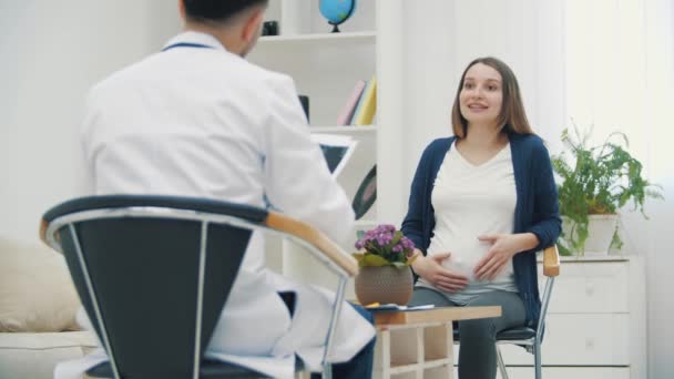 4k video de la mujer embarazada hablando con un médico. — Vídeo de stock