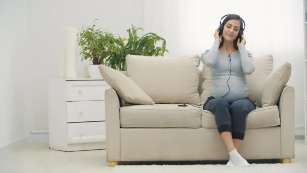 4k video of pregnant woman listening to music. — Stockvideo