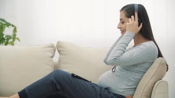 4k video of pregnant woman listening to music. — Stockvideo