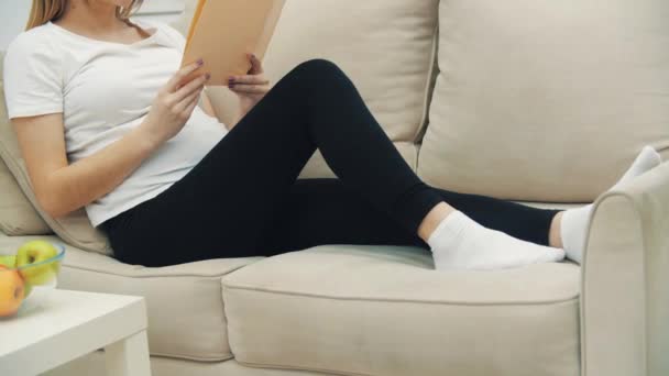 4k video de la mujer embarazada leyendo un libro. — Vídeo de stock