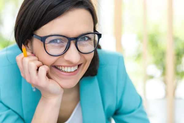 Close up photo of woman with pencil wearing black glasses. — Stock Photo, Image