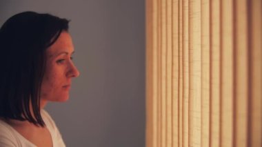 4k video 'da kadın pencereye bakıyor ve perdeler birini bekliyor..