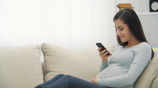 4k vídeo de la mujer en el sofá usando el teléfono. — Vídeo de stock