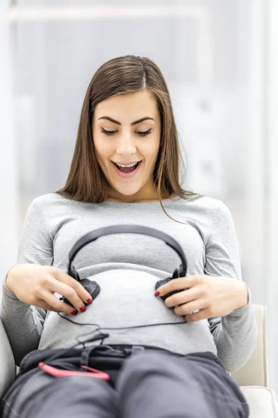 Foto von schönen schwangeren Frau mit Kopfhörern. — Stockfoto