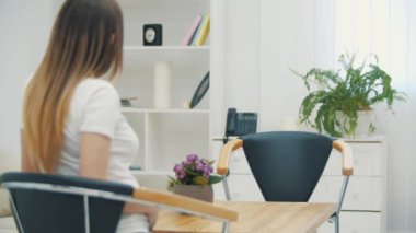 Doktorun beyaz laboratuvar önlüğü giyip ultrason fotoğraflarını tutarken ve açıklama yaparken 4K yavaş çekim videosu..