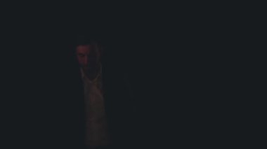 Siyah arka planda siyah takım giyen bir adamın 4K yavaş çekim videosu..