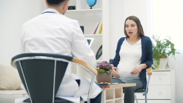 4k cámara lenta de vídeo de la mujer embarazada hablando con un médico. — Vídeos de Stock