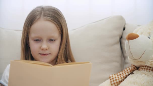 4k βίντεο βραδείας κίνησης του μικρού κοριτσιού που διαβάζει ένα βιβλίο. — Αρχείο Βίντεο