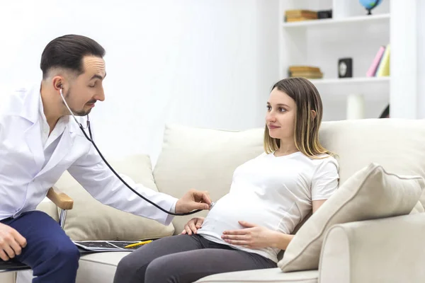임신 한 여자를 검사하러 가는 청진기를 가진 의사 의사의 사진. — 스톡 사진