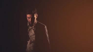 Siyah arka planda siyah takım giyen bir adamın 4K yavaş çekim videosu..