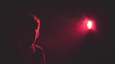 4k, gölgeli, dumanlı ve arka planda pembe ışıklı bir adamın videosunu kapat..