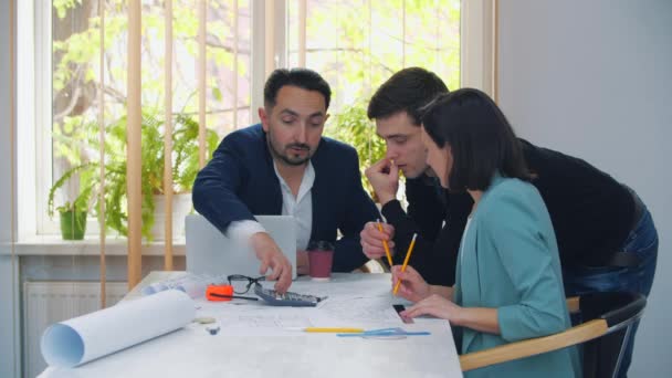 4k video de colegas en ropa formal discutiendo ideas de negocios mientras se reúnen en la mesa en la oficina moderna. — Vídeos de Stock